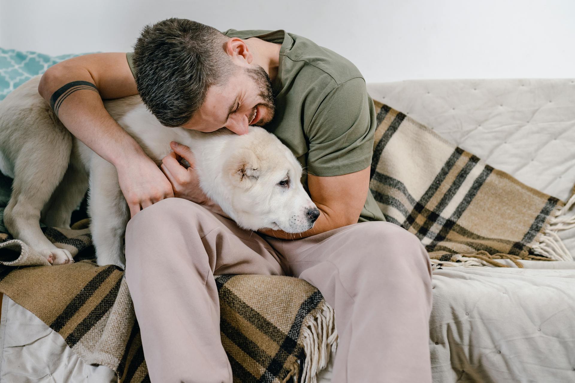 Foto van een man die zijn hond knuffelt