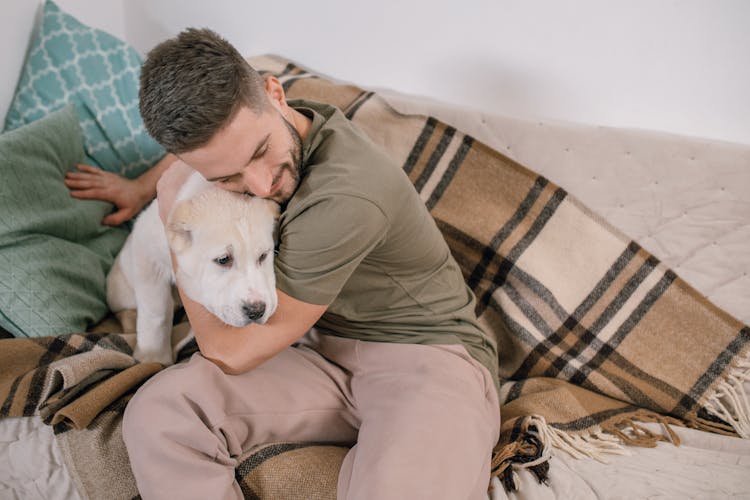 A Man Hugging A Dog 