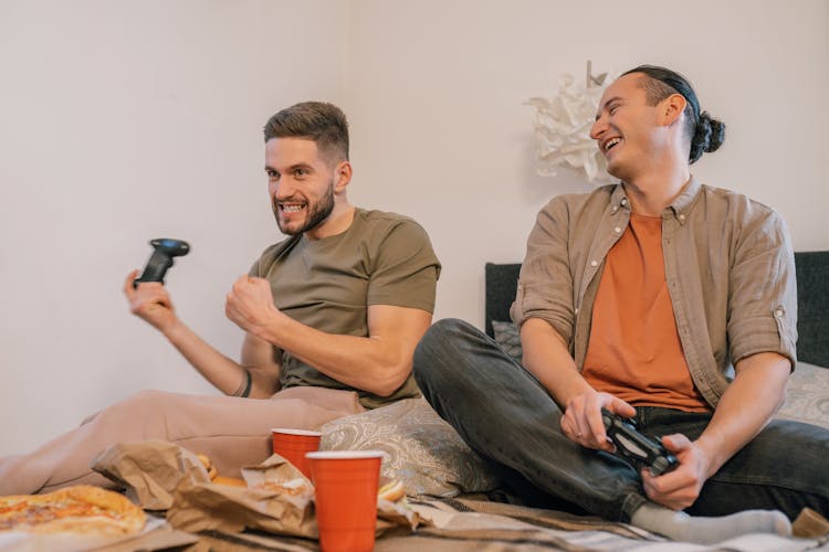 Smiling Friends Sitting On The Bed 