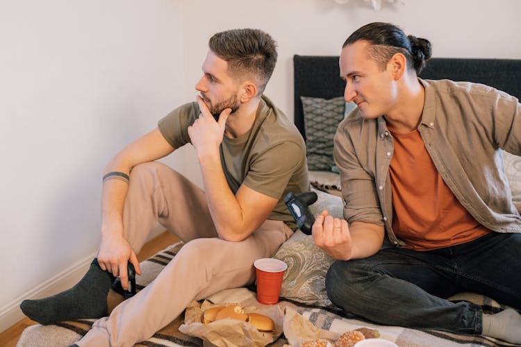 Photograph Of Men Sitting On A Bed