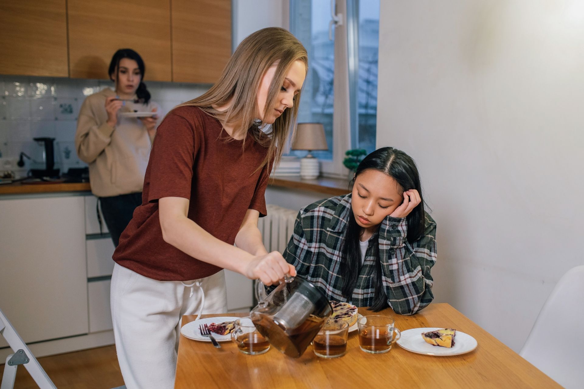 Two friends support each other over coffee, offering comfort and companionship.
