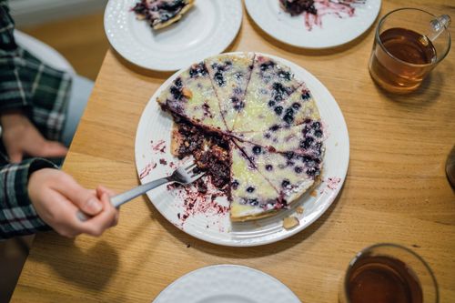 Free A delicious homemade blueberry pie with a fork held by a hand, perfect for dessert lovers. Stock Photo