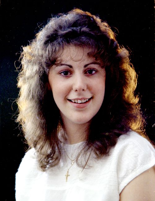 Free A cheerful caucasian woman with 1980s hairstyle under studio lighting. Stock Photo