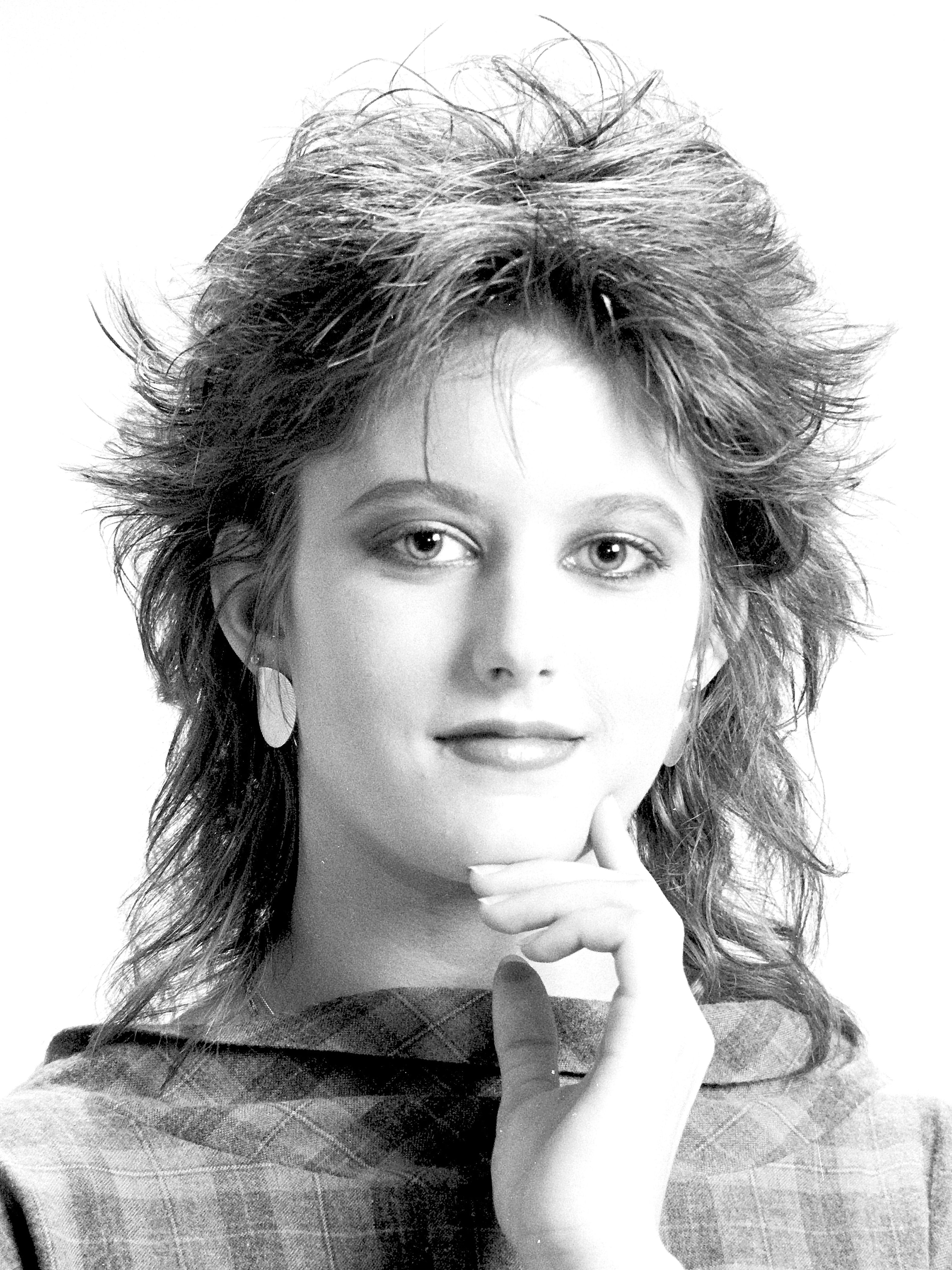 Classic black-and-white portrait of a woman with 1980s hairstyle, exuding retro charm.