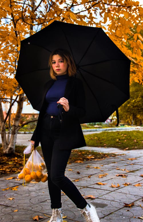 Woman Holding Umbrella While Walking
