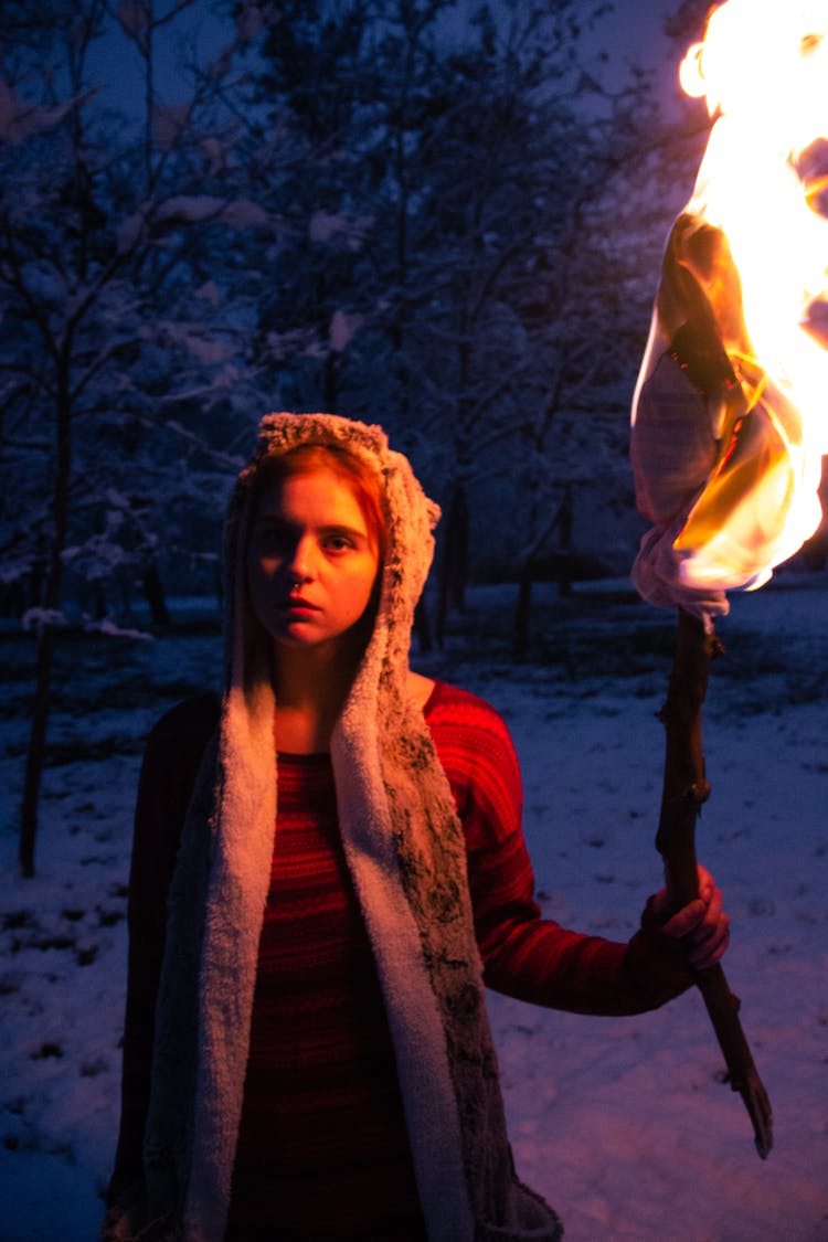 A Woman Holding A Torch In The Forest