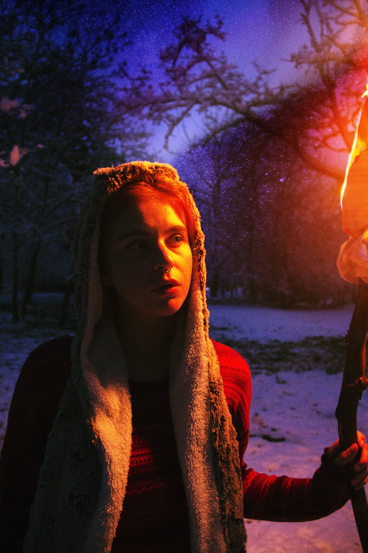 A Woman Holding A Torch In The Forest