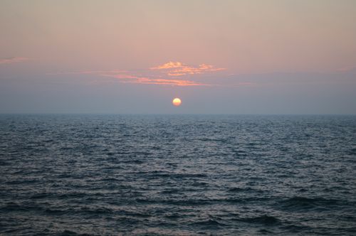 Free Peaceful sunset view with a calm ocean and colorful sky, capturing tranquility and beauty. Stock Photo