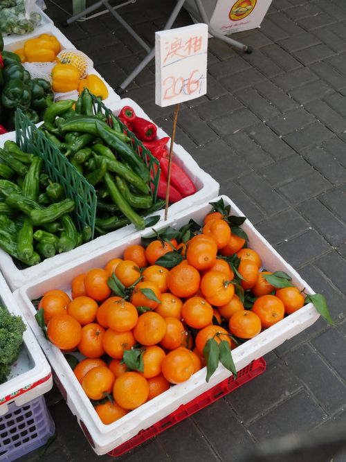 Free Fresh tangerines displayed at a market stand in Hong Kong. High-angle view shows vibrant produce. Stock Photo