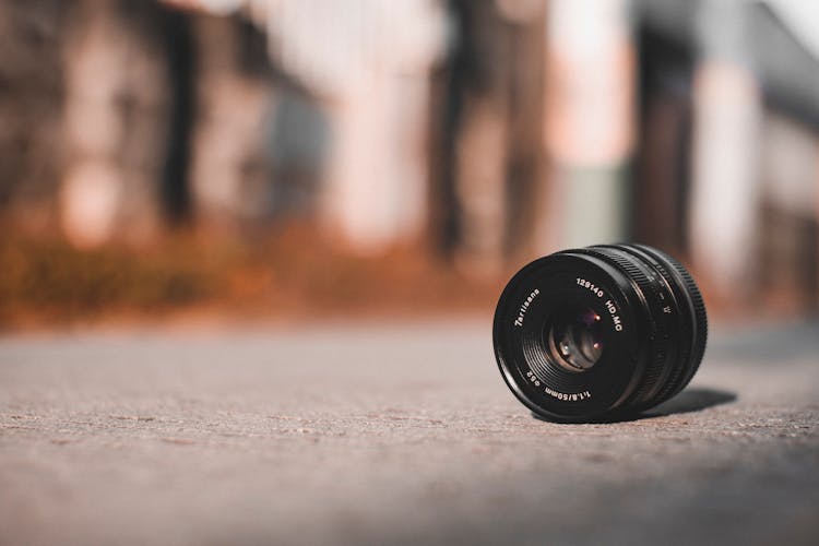 Professional Photo Camera Lens On Pavement In Town