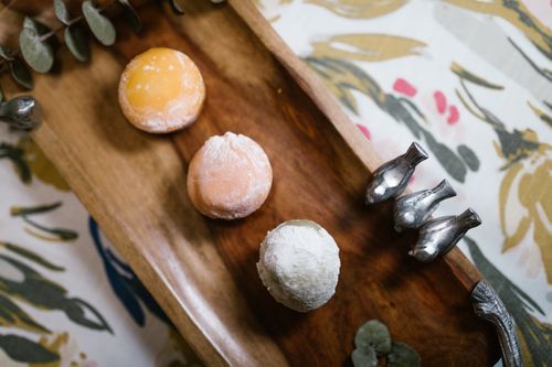 Free A vibrant assortment of mochi desserts elegantly presented on a wooden tray, perfect for food photography and culinary visuals. Stock Photo