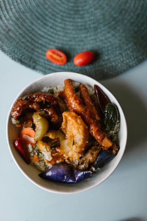 Free A vibrant and appetizing Asian fusion dish with colorful vegetables and meats in a white bowl. Stock Photo