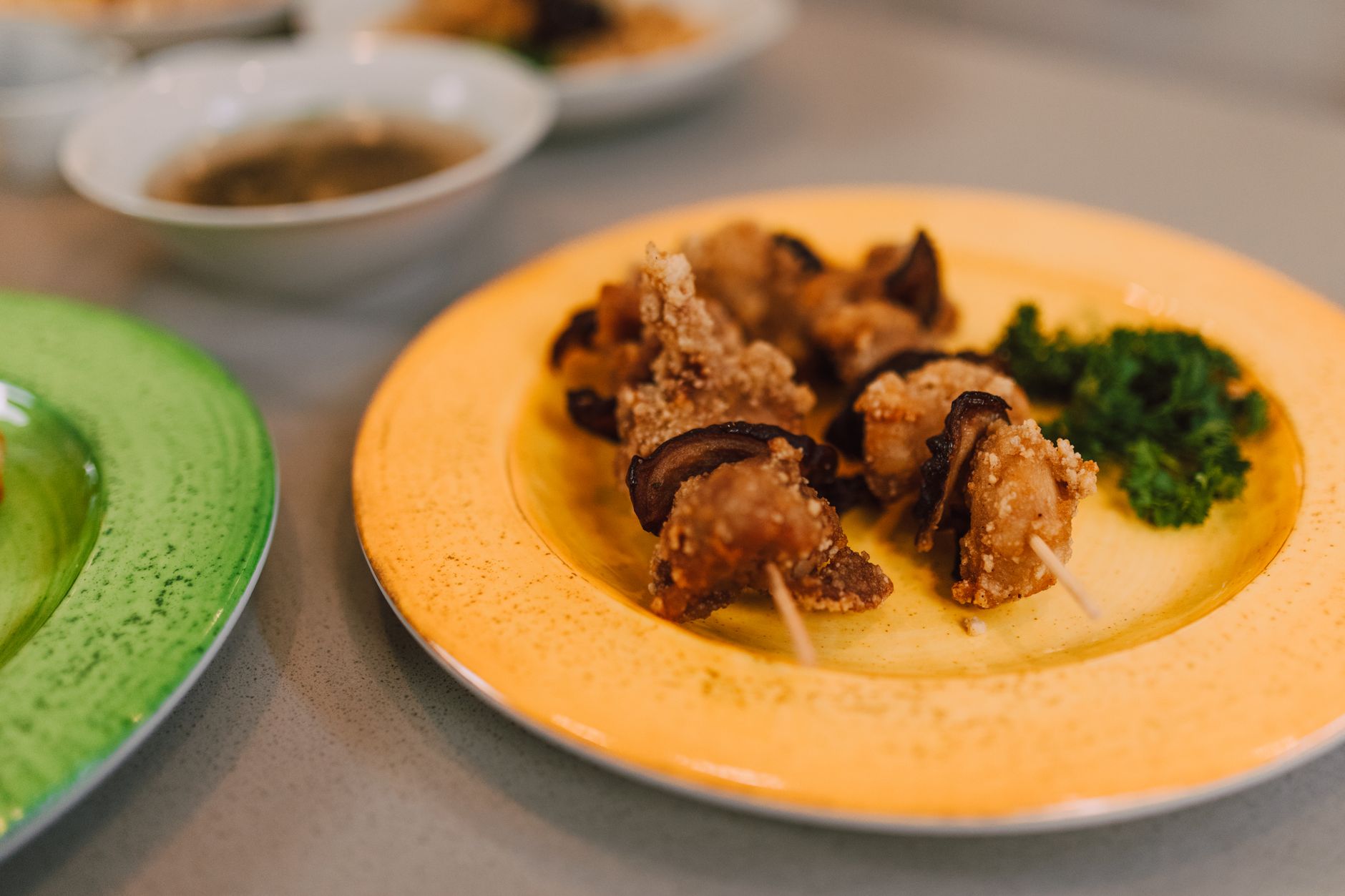 Close-up of Asian mushroom appetizers with garnish served on colorful plates, creating an appetizing and vibrant presentation.