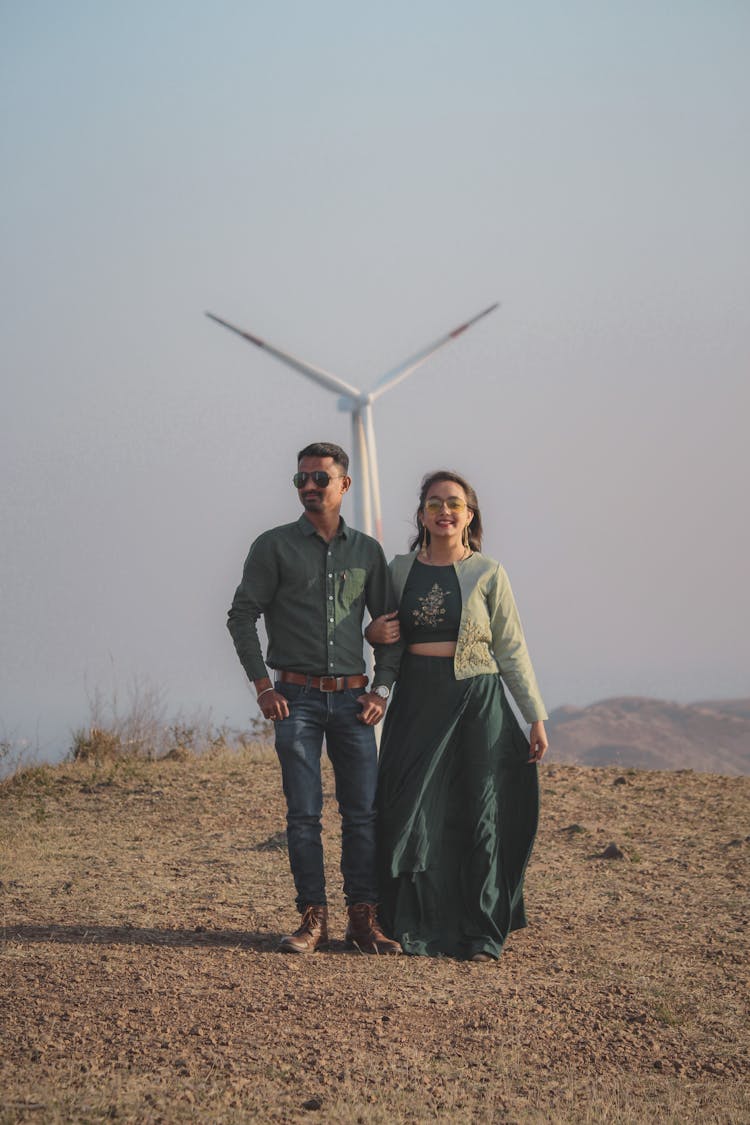 Indian Couple Standing On Hill Near Windmill