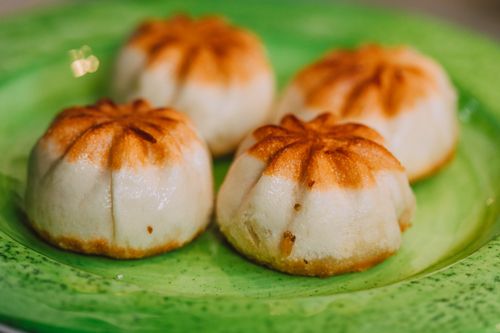 Free Delicious traditional mooncakes beautifully arranged on a vibrant green plate, showcasing intricate designs. Stock Photo