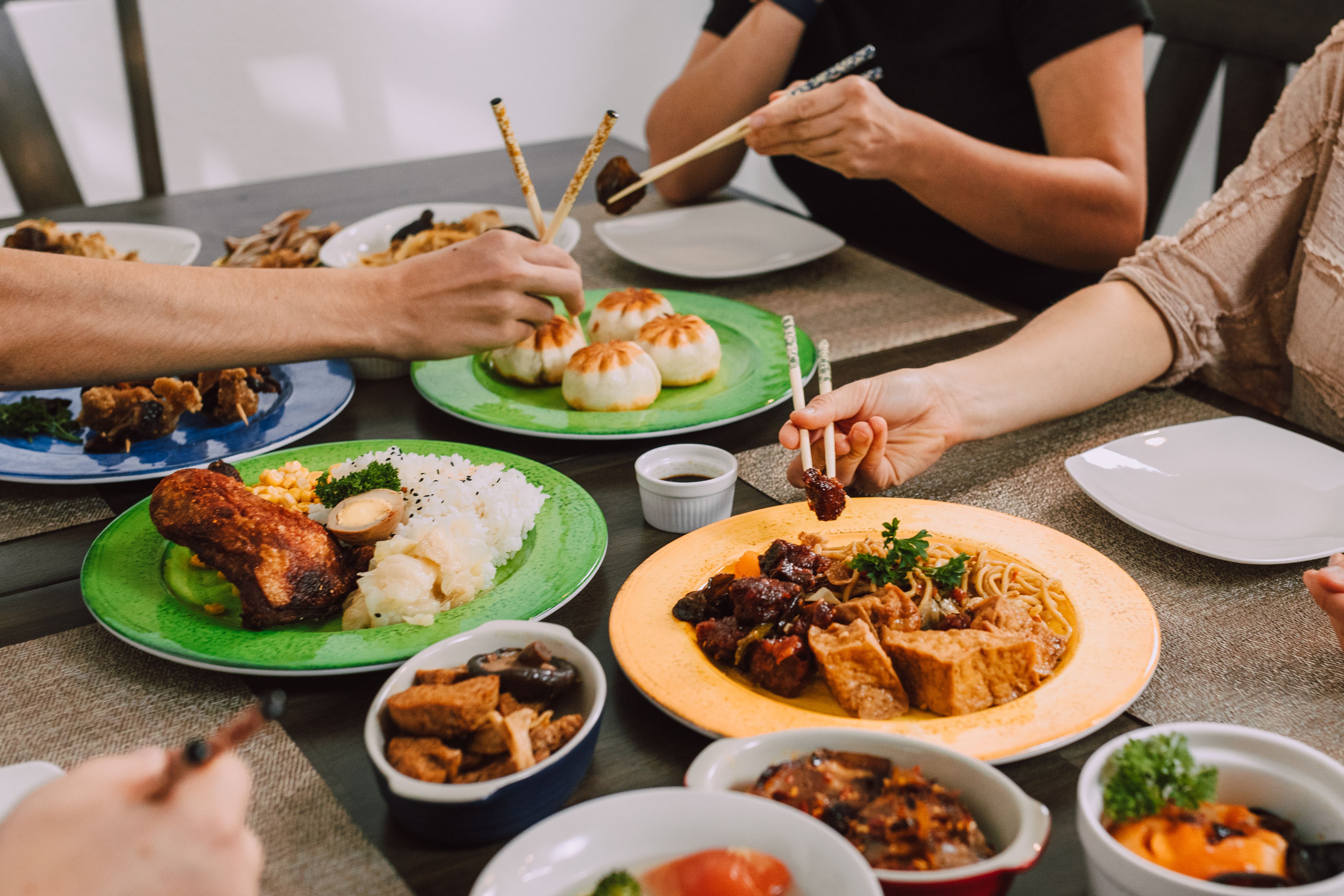 People Eating Food on the Plates Using Chopsticks · Free Stock Photo