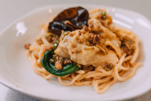 Free A delicious Asian noodle dish topped with dumplings and garnished on a plate. Stock Photo