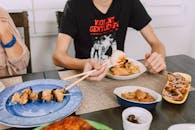 Man in Black Crew Neck T-shirt Holding Chopsticks with Mooncake