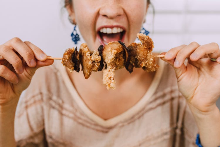 A Woman Holding A Skewer