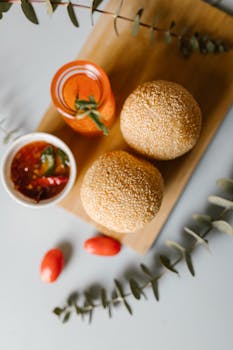 Top view of sesame balls, dipping sauce, and a refreshing drink beautifully arranged on a board.