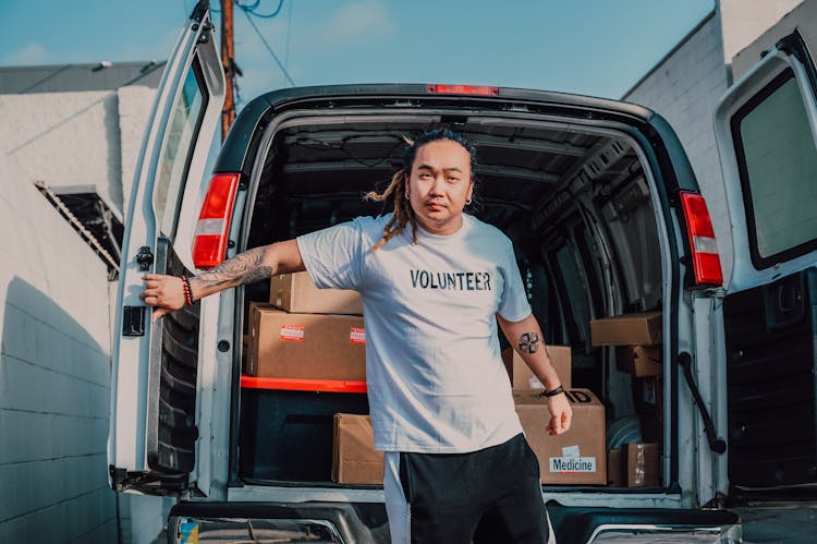 A Man Standing Behind The Van 