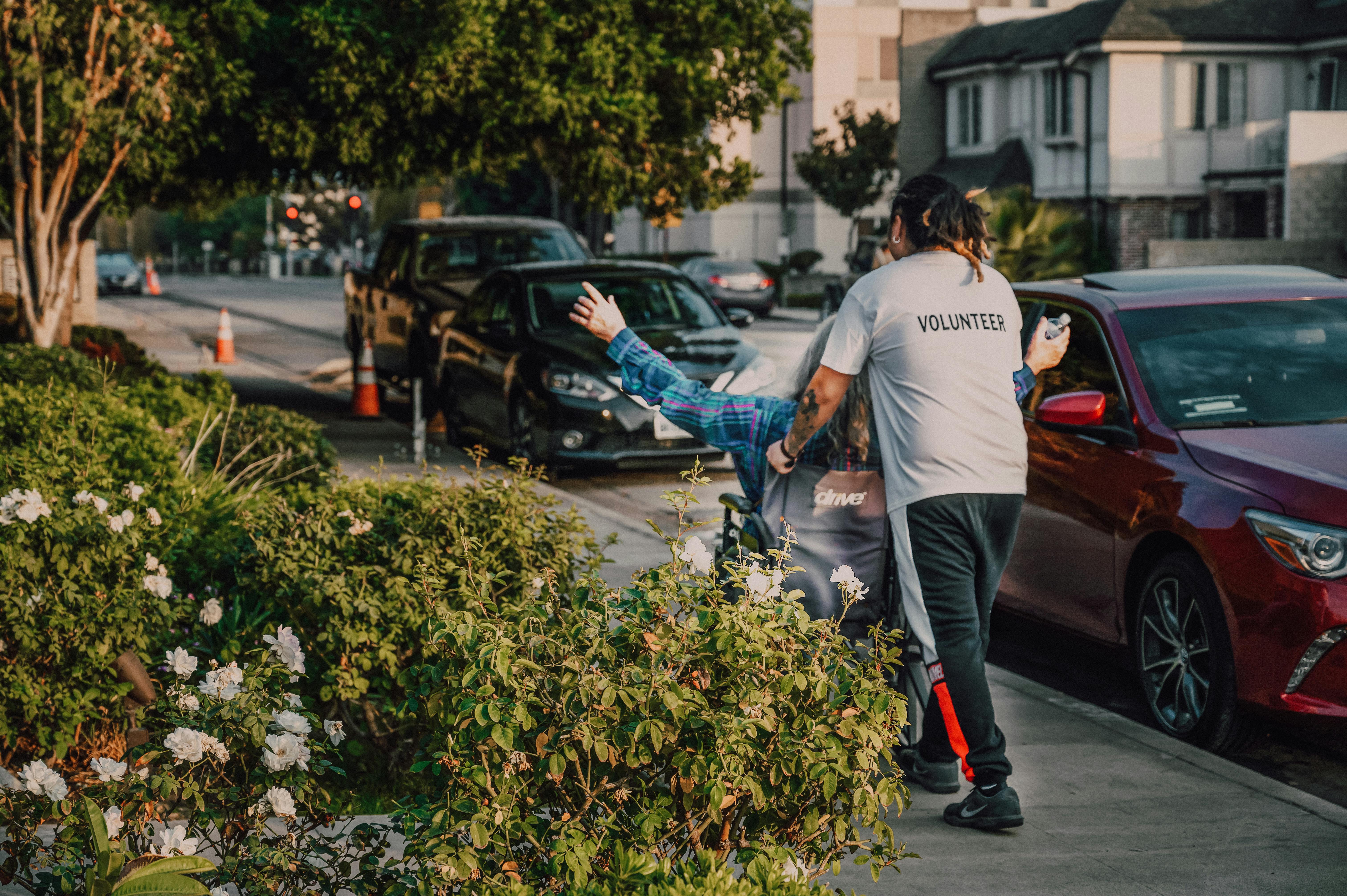 a man pushing a wheelchair on the street