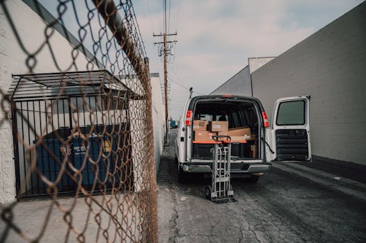An open van loaded with boxes in an alley, ready for donation deliveries.