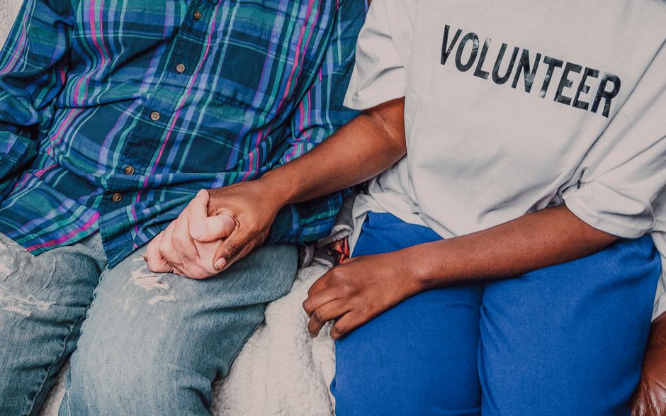 close-up of hands helping hands, community volunteers, warm natural light, emotional connection