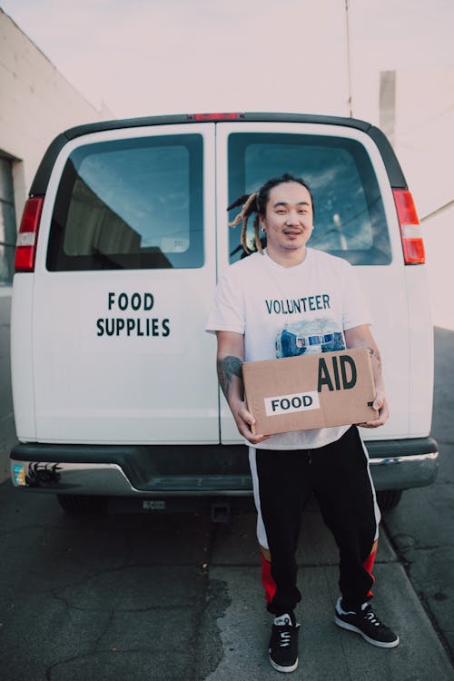 A Man Carrying a Box of Food Aid