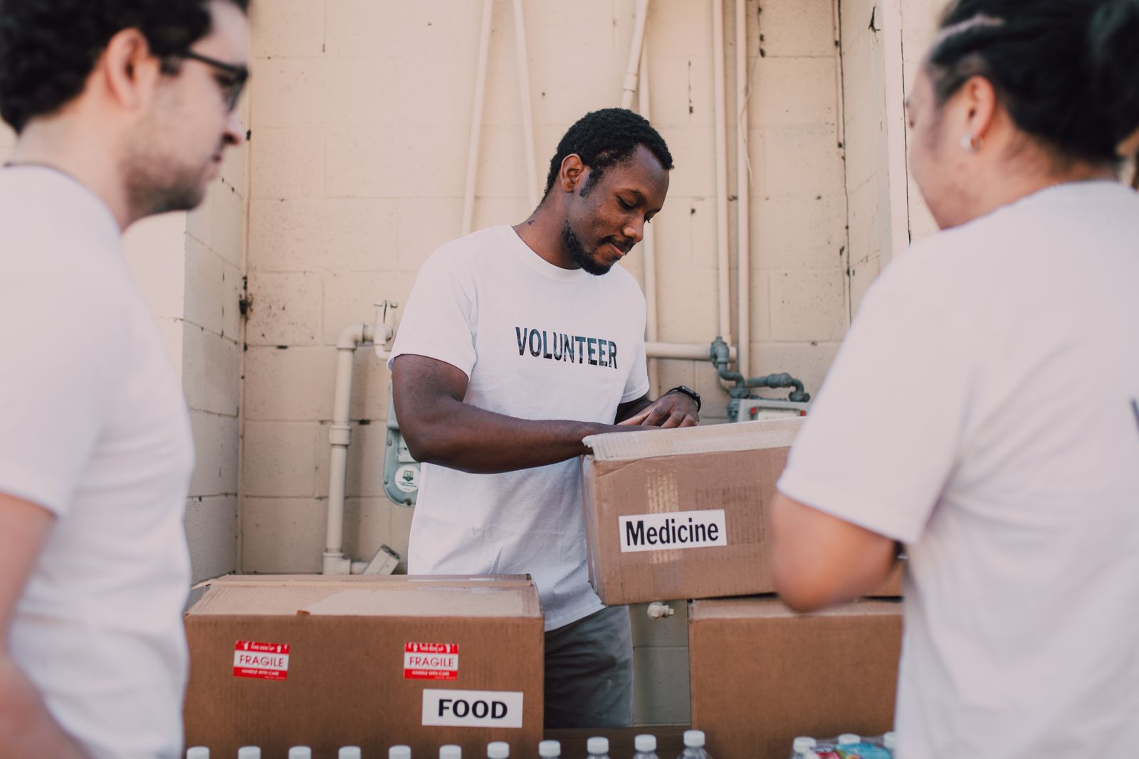 Volunteers packing food and supply boxes together, illustrating selfless service central to karma yoga