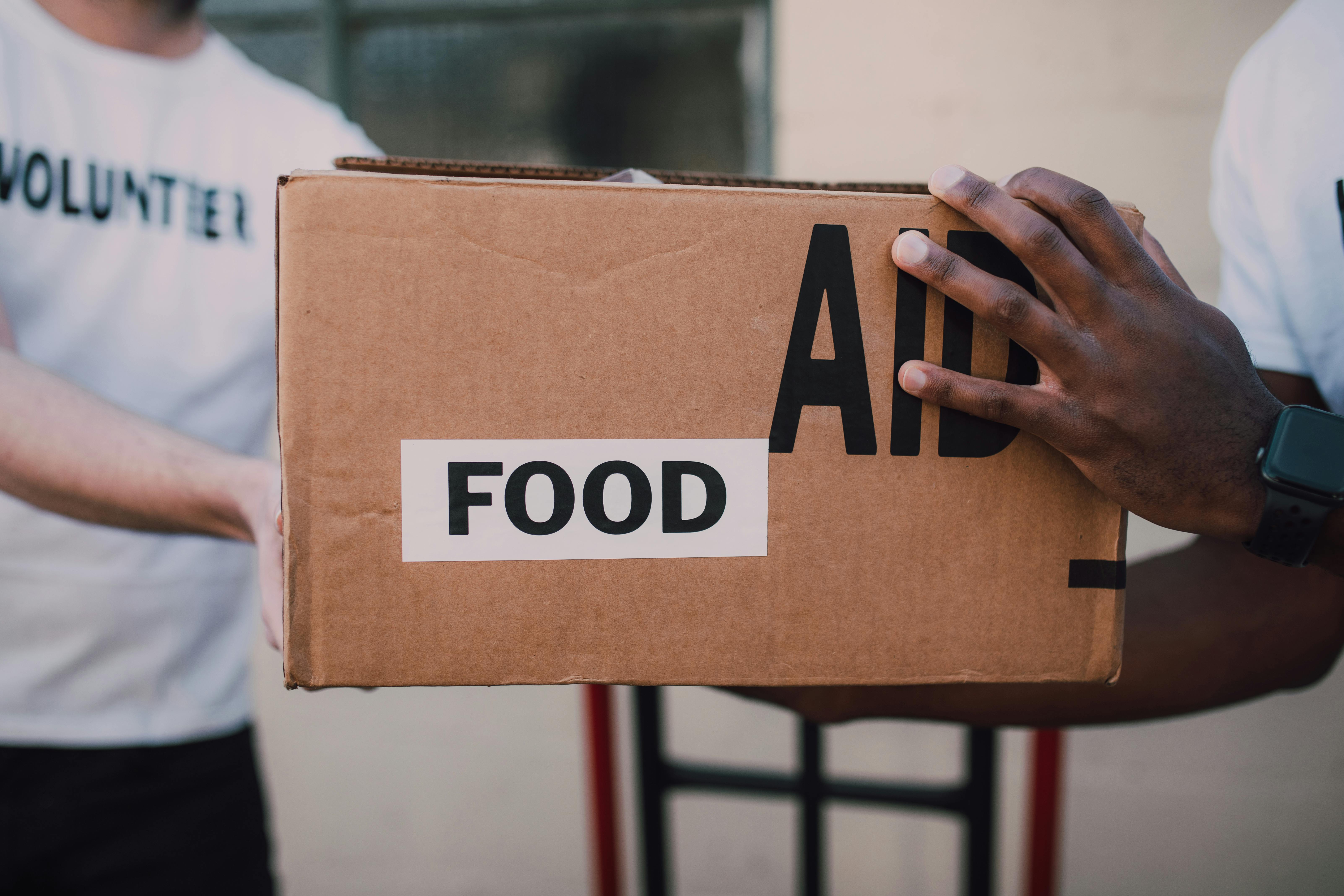 people handing over a brown box with label