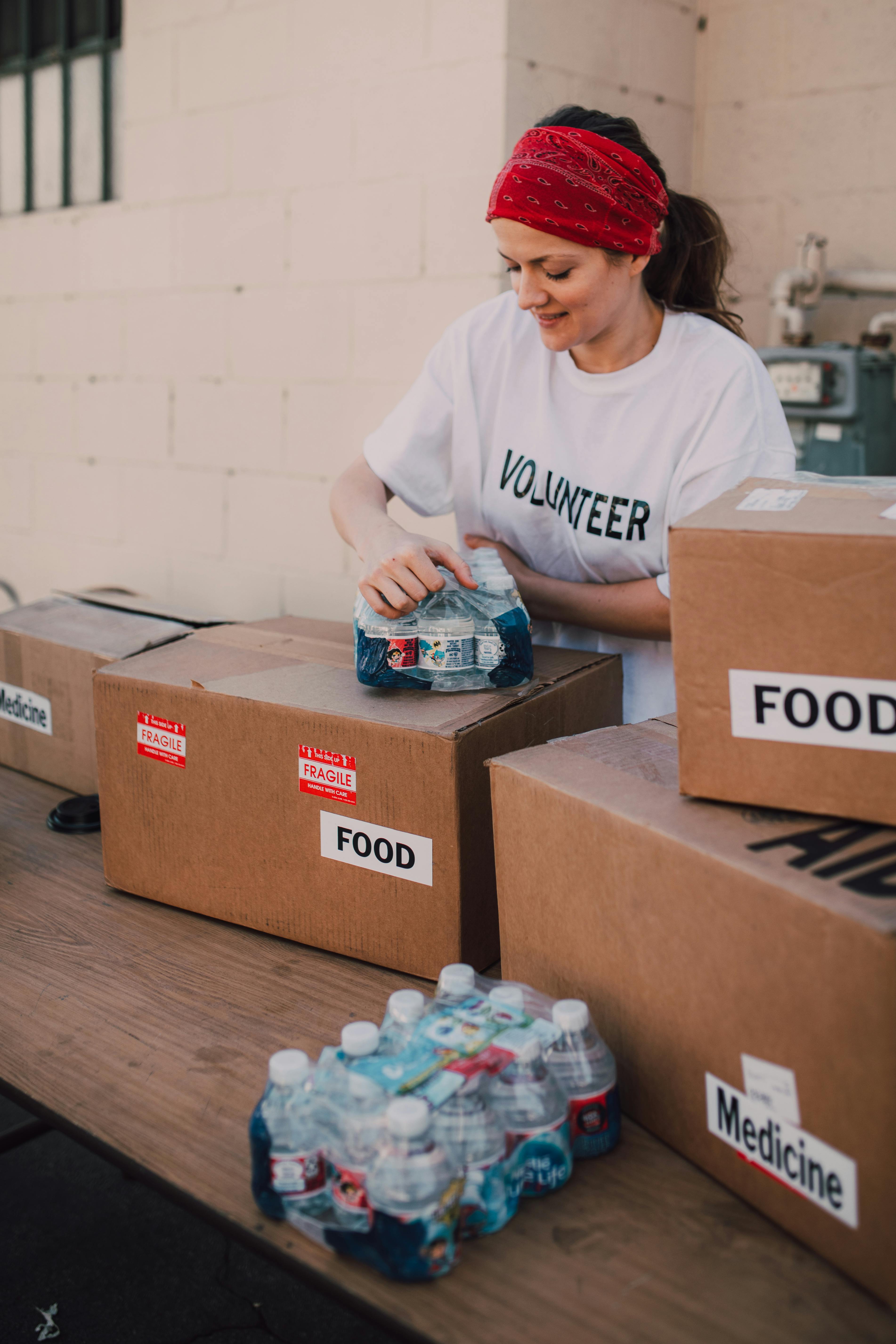 a woman holding bottles of drinks on top of a brown box