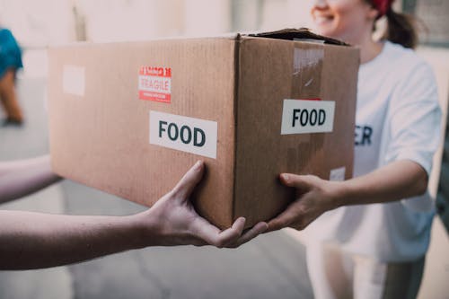 Free People Handing Over a Brown Box Stock Photo