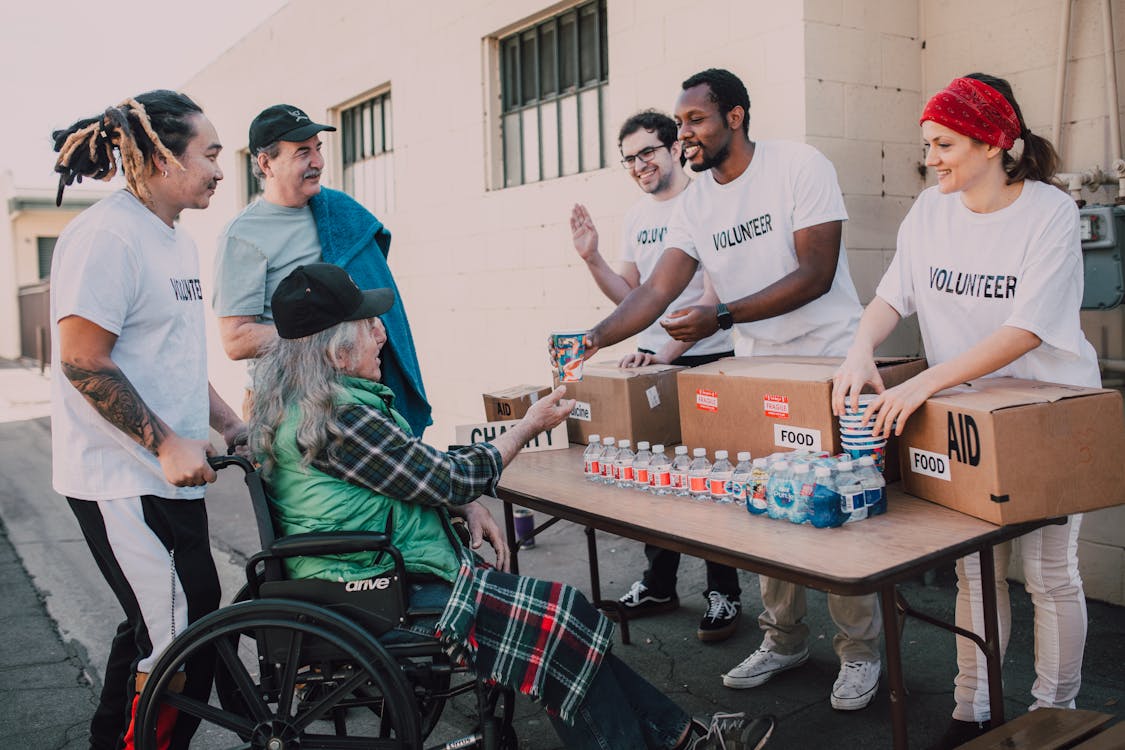 Man in White Crew Neck T-shirt Sitting on Black Wheelchair