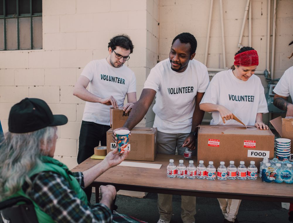 Volunteers distributing food and drinks outdoors