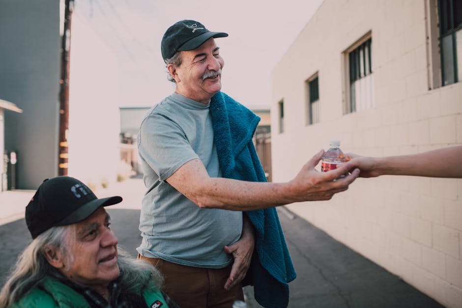 Two adults exchanging bottled water with kindness in an urban setting. Two adults exchanging bottled water with kindness in an urban setting.