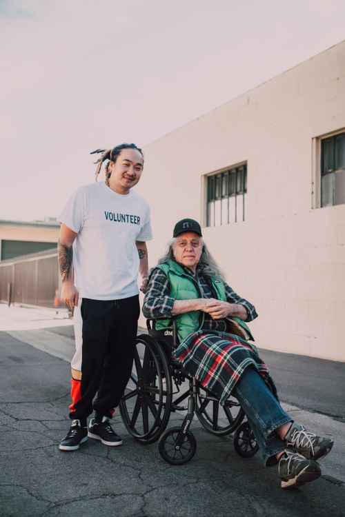 Free A volunteer helps a person in a wheelchair outdoors, showcasing compassion and support. Stock Photo