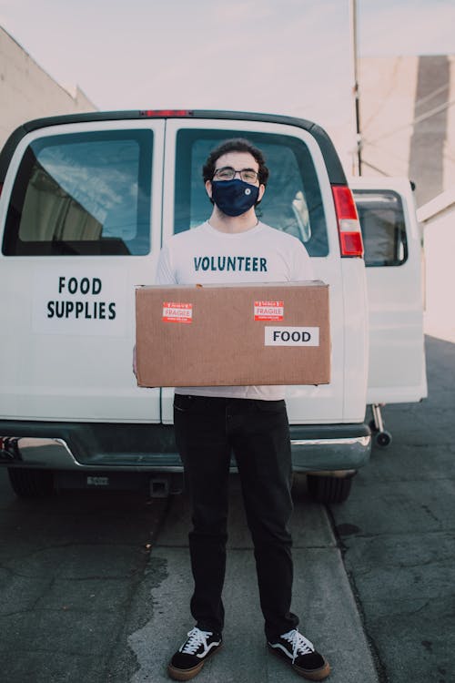 A Male Volunteer Carrying a Box