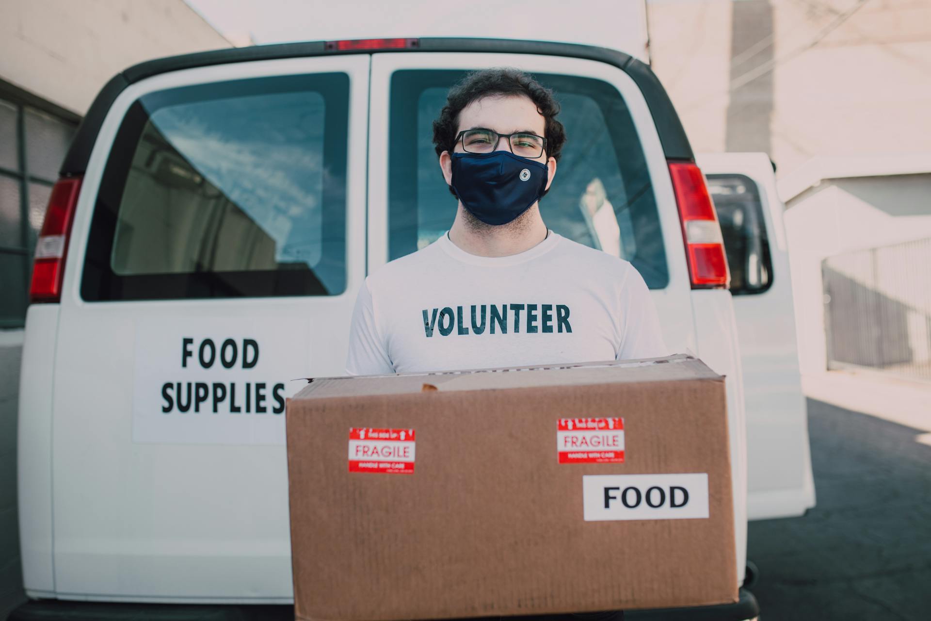 A Man Carrying a Box with Food Label