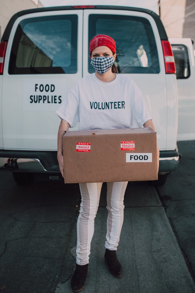 A Female Volunteer Carrying A Box