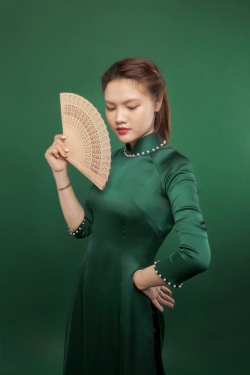 A Pretty Woman in Green Dress Holding a Hand Fan