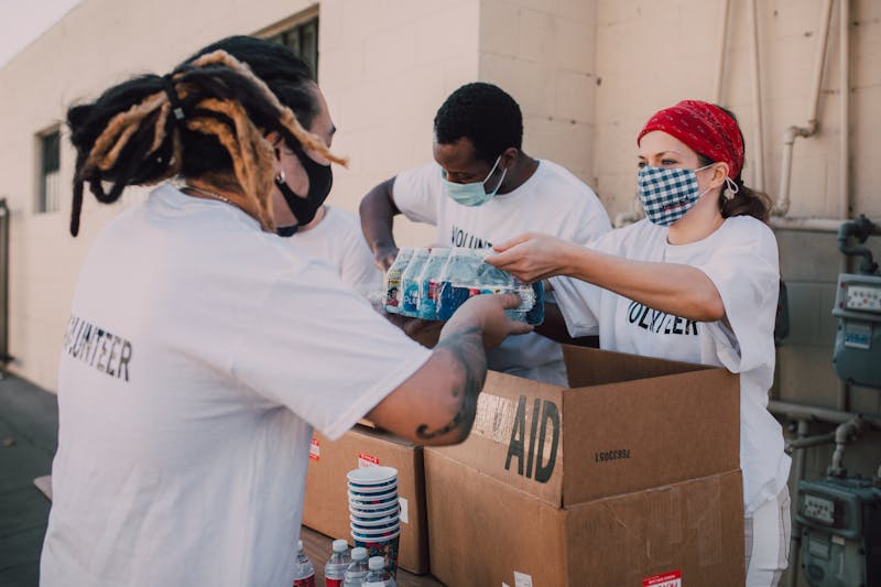 Volunteers wearing masks distributing aid