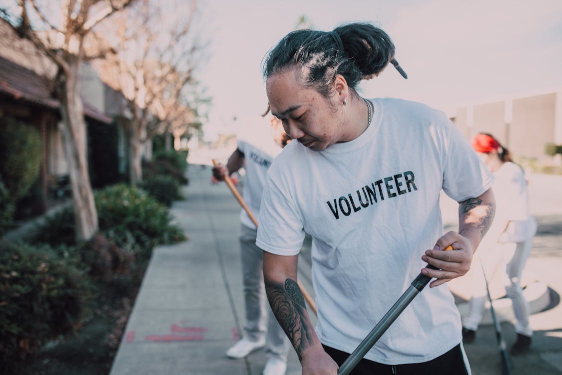 Free Volunteers Sweeping the Sidewalk Stock Photo