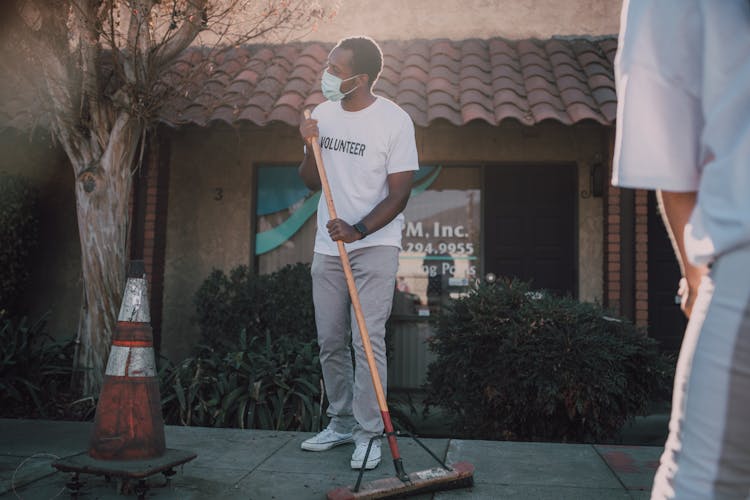 Man Wearing Face Mask Cleaning The Sidewalk