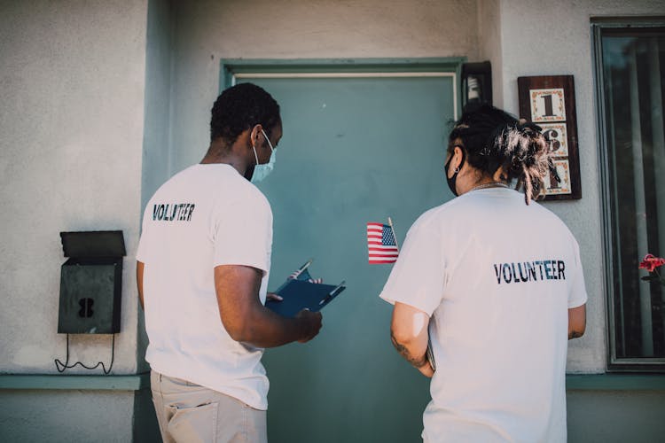 Two Men Wearing White Volunteer T-shirt