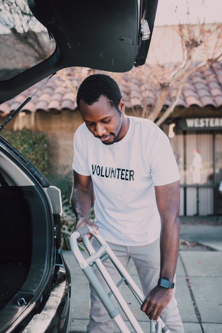 Man Putting The Walker In The Car Trunk