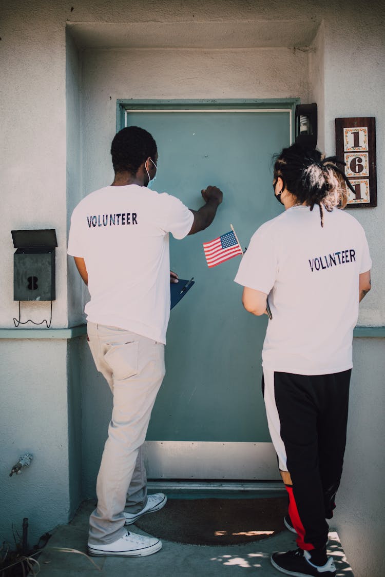 Two Men Knocking On The Blue Door