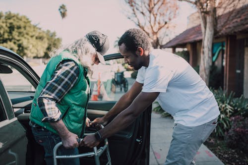 Free Man Assisting Person with Walker Stock Photo