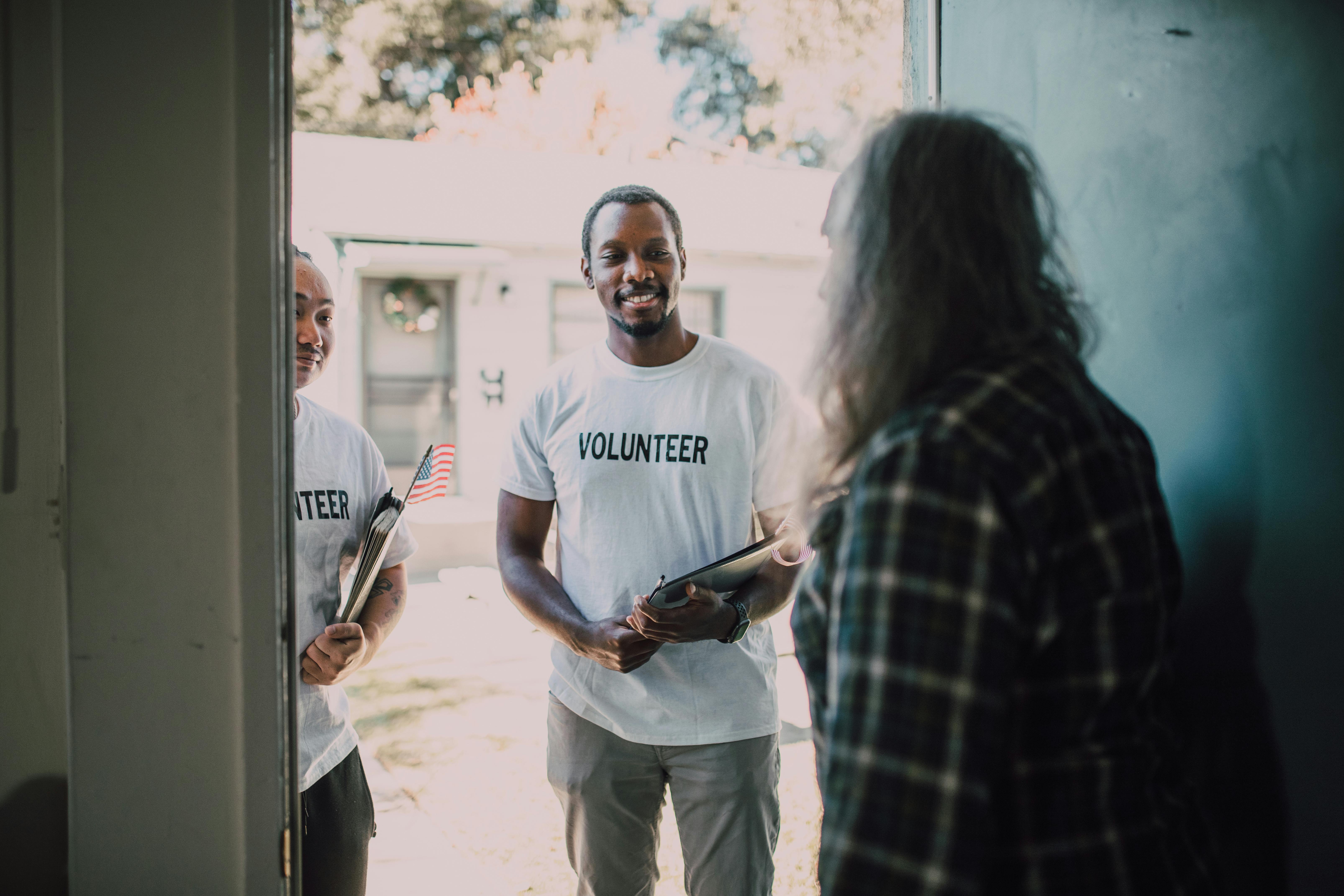 volunteer men in white shirt standing on the entrance door