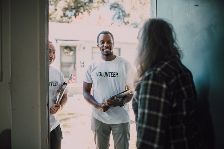 Volunteer Men In White Shirt Standing On The Entrance Door